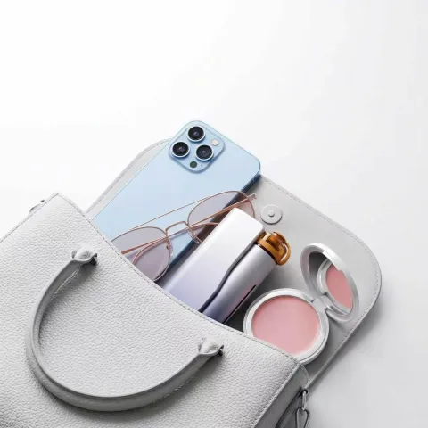 Zhithera D1 waterless diffuser in an open handbag with a phone, sunglasses and compact