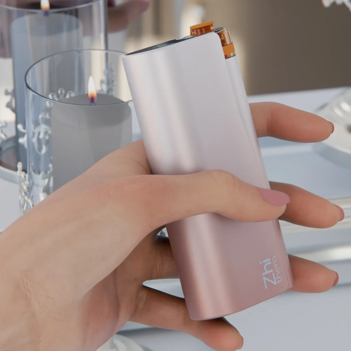 Hand holding the rose-gold Zhithera D1 waterless diffuser in front of a lit glass candle