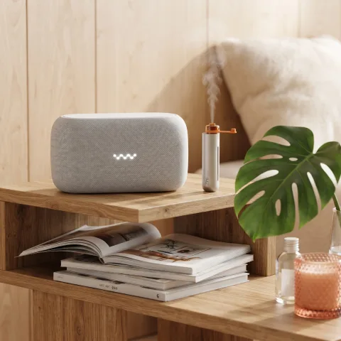 Zhithera D1 Mini waterless diffuser misting on a wooden shelf next to a speaker and plant