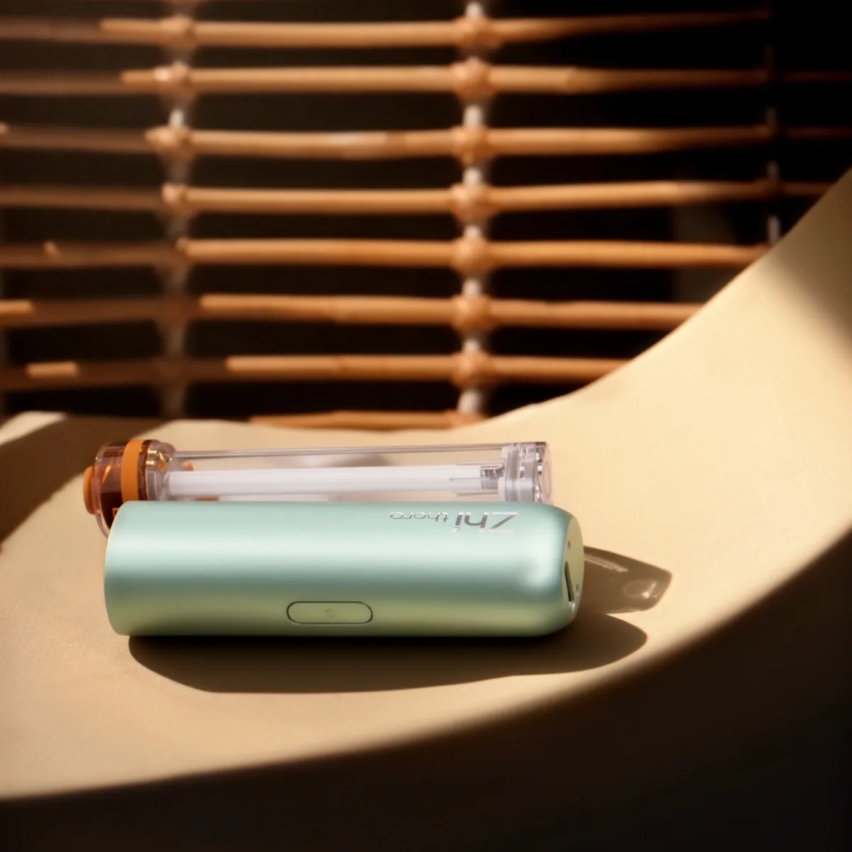 Mint-green Zhithera D1 Mini car diffuser with a clear refillable cartridge on a curved shelf