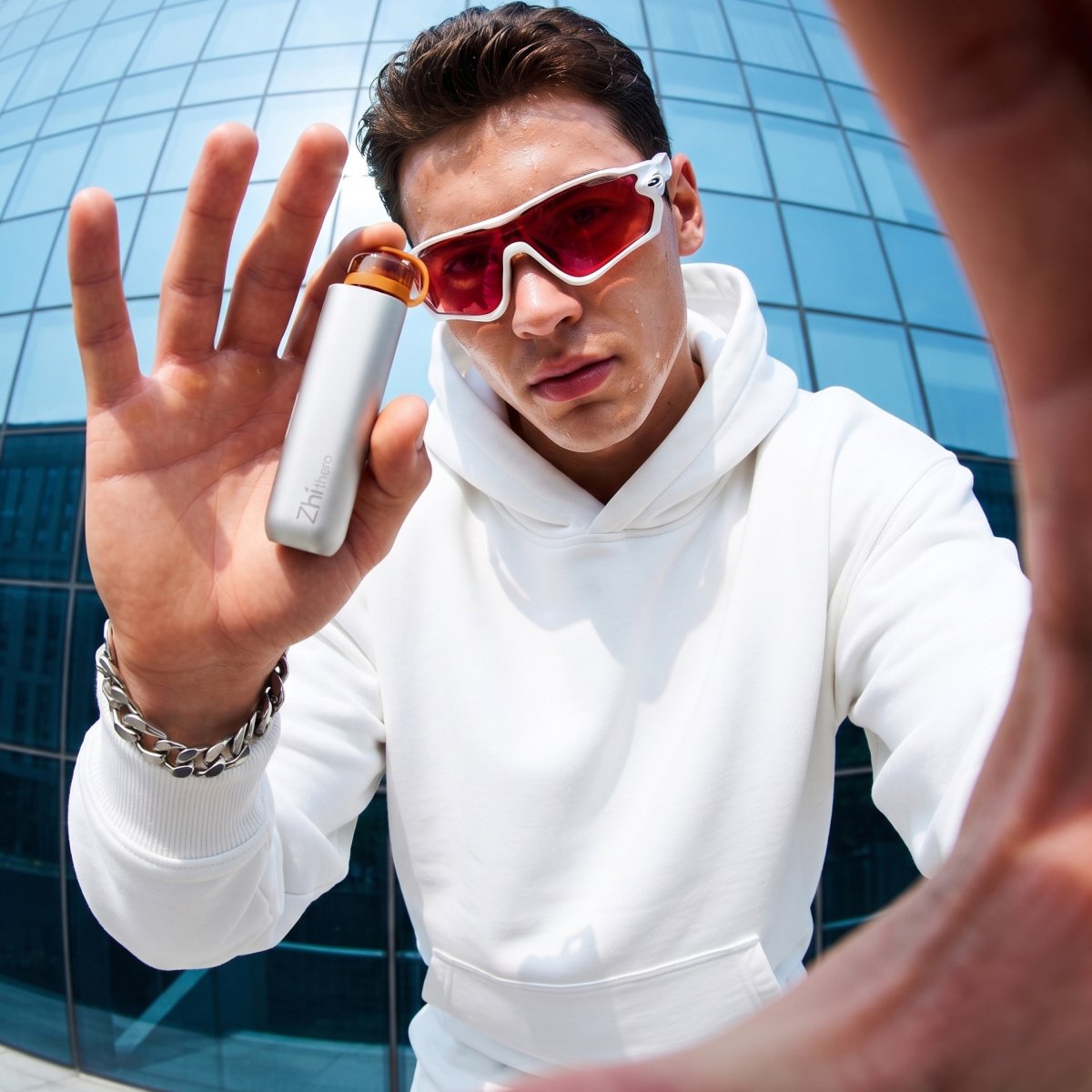 Man in sunglasses holding up the Zhithera D1 Mini portable waterless diffuser outdoors