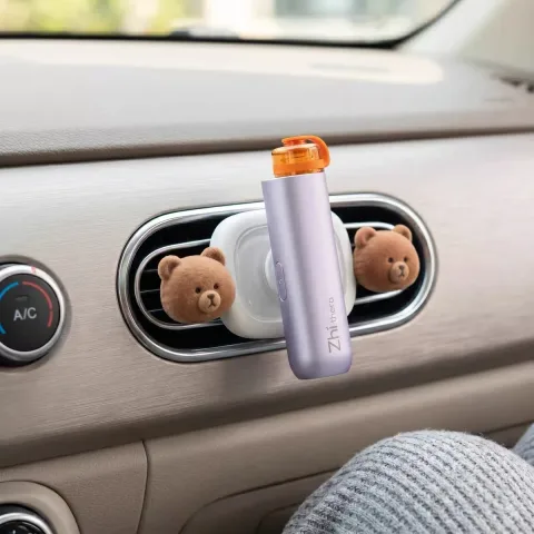 Man in sunglasses holding up the Zhithera D1 Mini portable waterless diffuser outdoors